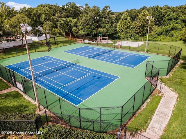 view of tennis court with a yard