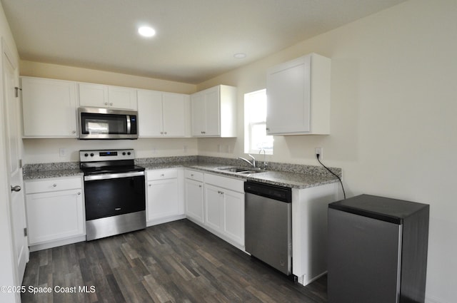 kitchen featuring dark wood-type flooring, stainless steel appliances, sink, and white cabinets