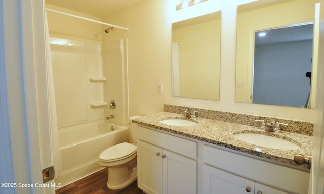 bathroom featuring double vanity, a sink, toilet, and wood finished floors