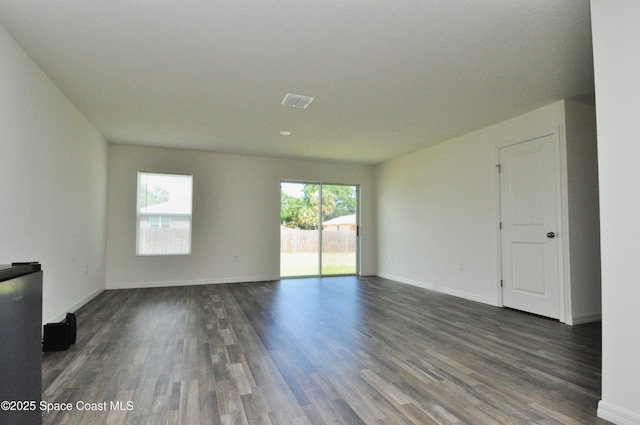 interior space with baseboards, dark wood-style flooring, and visible vents