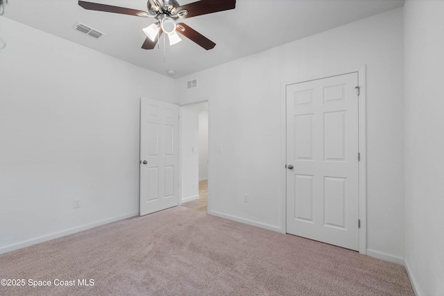 unfurnished bedroom with light colored carpet and ceiling fan