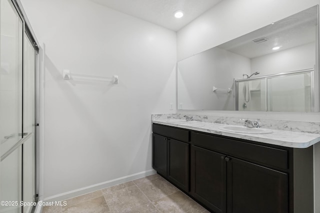 bathroom with an enclosed shower, vanity, and a textured ceiling