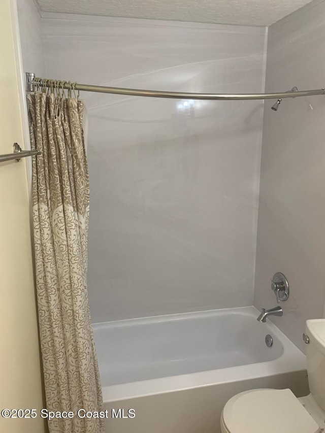 bathroom featuring shower / bathtub combination with curtain and toilet