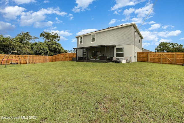 rear view of house with a sunroom and a lawn