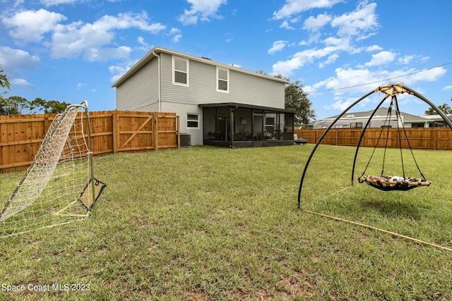 back of house with a sunroom, a lawn, and central air condition unit