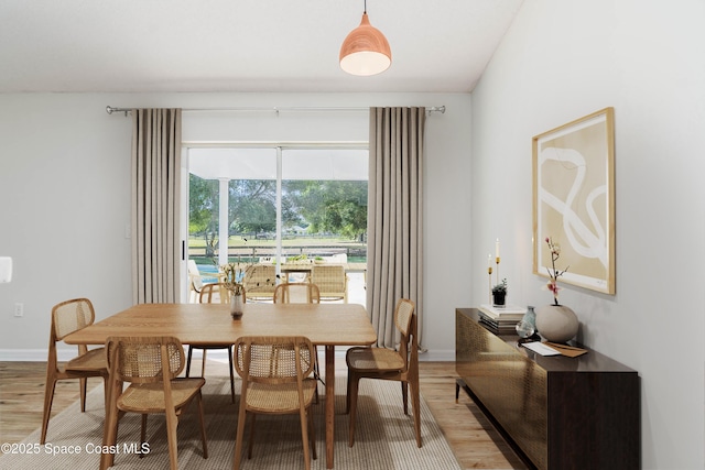 dining area featuring baseboards and light wood-style floors
