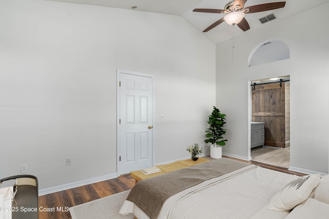 bedroom with high vaulted ceiling, visible vents, baseboards, and wood finished floors