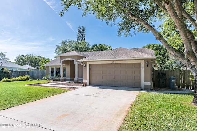 ranch-style house featuring stucco siding, fence, a front lawn, a garage, and concrete driveway