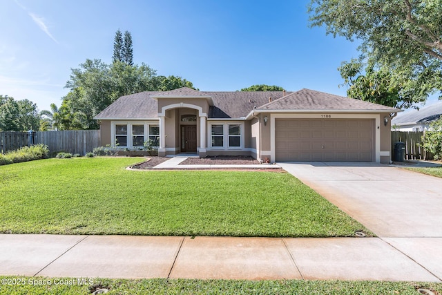 view of front of home featuring an attached garage, stucco siding, fence, and a front lawn