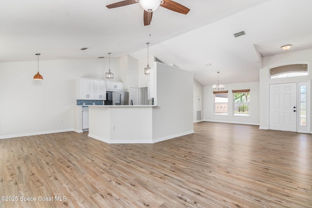 unfurnished living room with light wood finished floors, visible vents, ceiling fan with notable chandelier, and baseboards