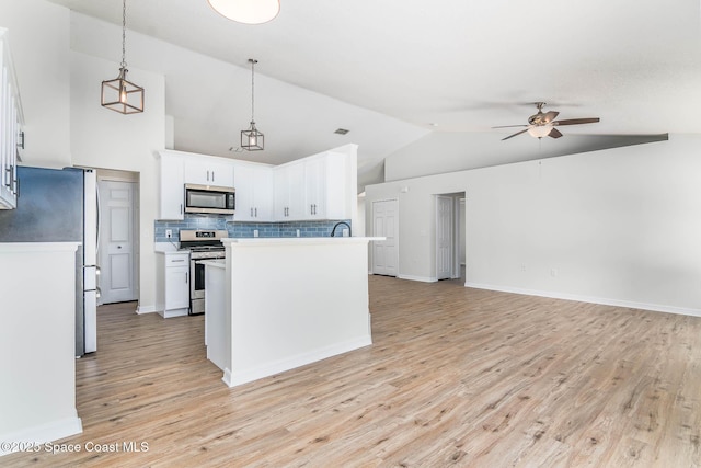 kitchen with ceiling fan, tasteful backsplash, appliances with stainless steel finishes, open floor plan, and light wood finished floors