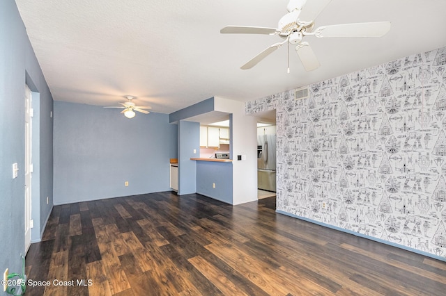 unfurnished living room featuring dark hardwood / wood-style floors and ceiling fan