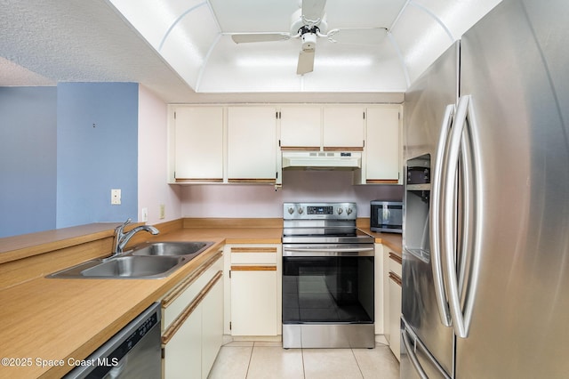 kitchen featuring sink, light tile patterned floors, ceiling fan, white cabinetry, and stainless steel appliances