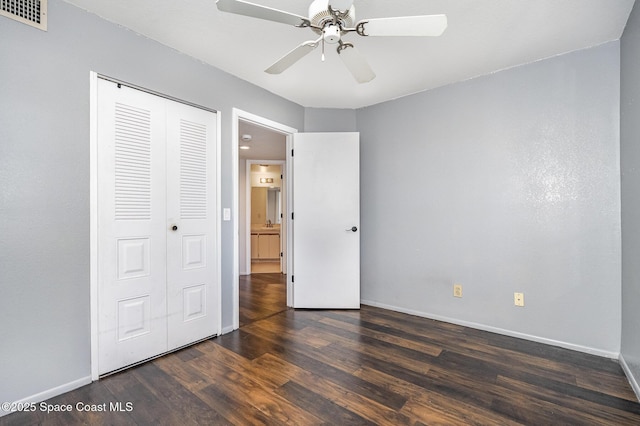 unfurnished bedroom featuring dark hardwood / wood-style flooring, a closet, and ceiling fan