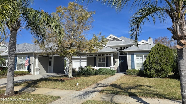 view of front of property featuring a garage, a front lawn, and a porch