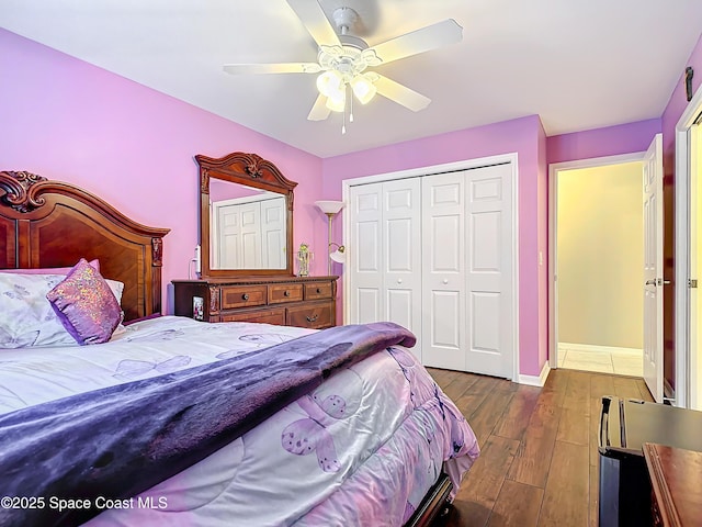 bedroom featuring dark wood-type flooring, ceiling fan, and a closet