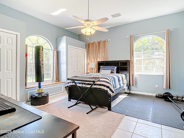 bedroom with multiple windows, tile patterned floors, and ceiling fan