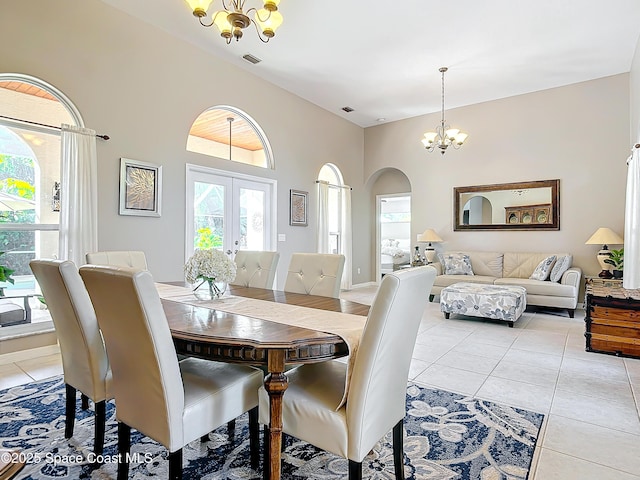 tiled dining room with an inviting chandelier and french doors