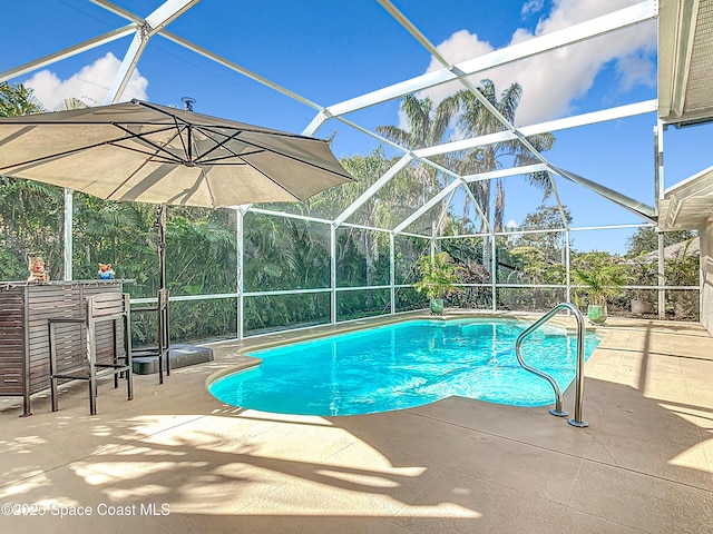 view of pool featuring a patio, an outdoor bar, and glass enclosure