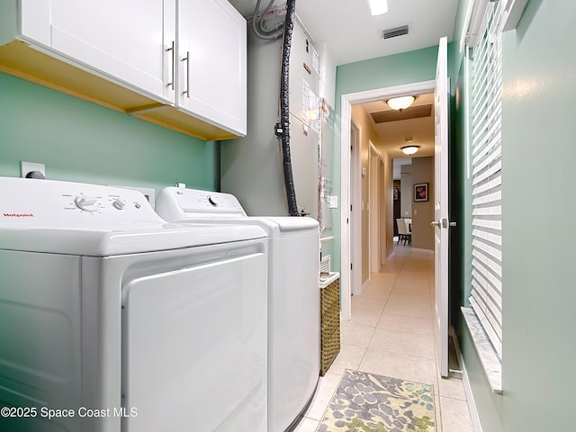 washroom featuring cabinets, washer and dryer, and light tile patterned floors