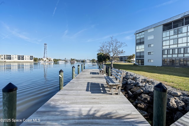 dock area with a water view and a yard