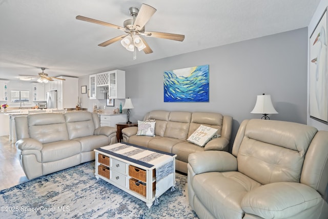 living room with ceiling fan and light hardwood / wood-style floors