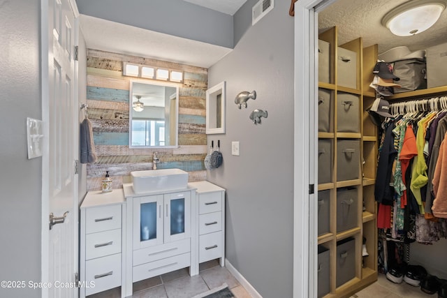 bathroom with vanity, ceiling fan, tile patterned flooring, and a textured ceiling