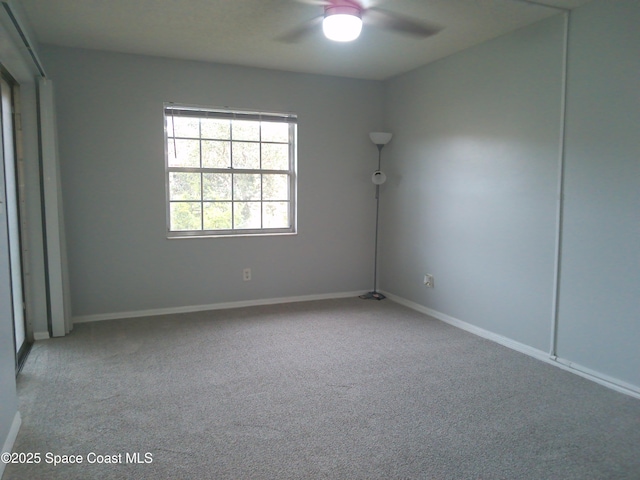 carpeted spare room featuring ceiling fan