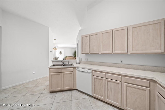 kitchen with light brown cabinetry, sink, light tile patterned floors, white dishwasher, and kitchen peninsula