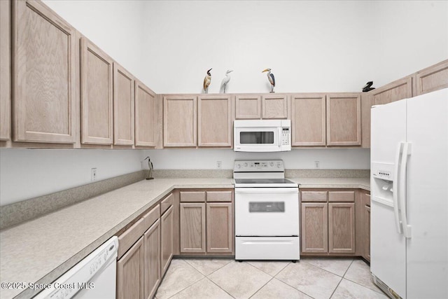 kitchen featuring light tile patterned floors and white appliances