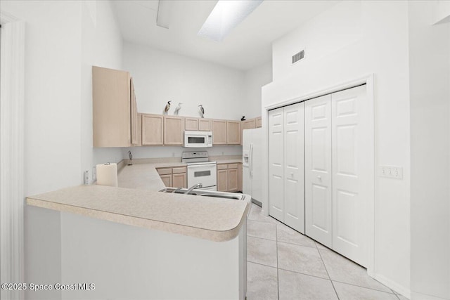 kitchen featuring light brown cabinetry, sink, light tile patterned floors, kitchen peninsula, and white appliances