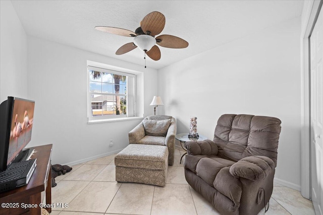 living area with ceiling fan and light tile patterned flooring