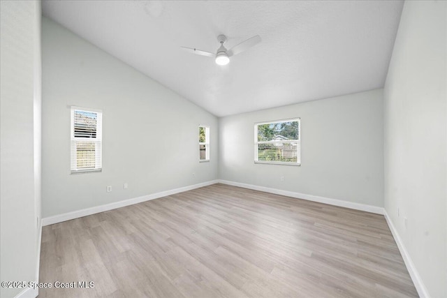 empty room with light hardwood / wood-style flooring, ceiling fan, and vaulted ceiling