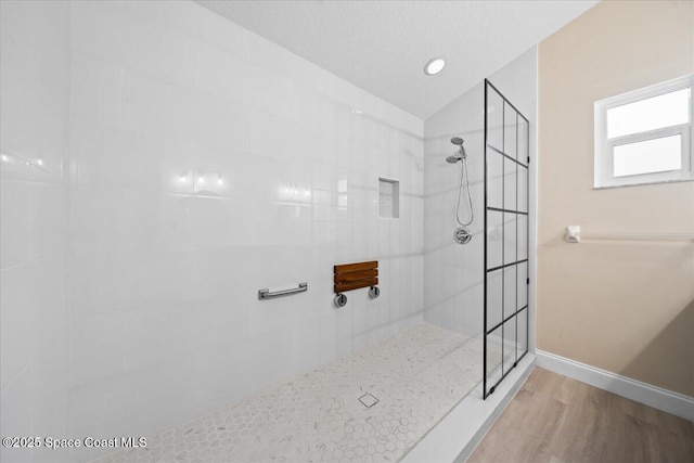 bathroom featuring vaulted ceiling, tiled shower, and hardwood / wood-style floors