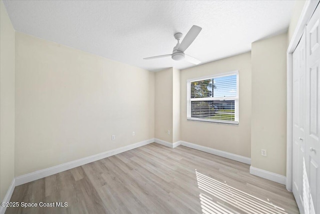 unfurnished bedroom featuring ceiling fan, a textured ceiling, light wood-type flooring, and a closet