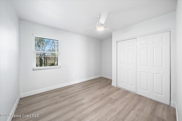 unfurnished bedroom with ceiling fan, light hardwood / wood-style floors, and a closet