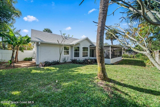 view of front of house featuring a sunroom and a front yard