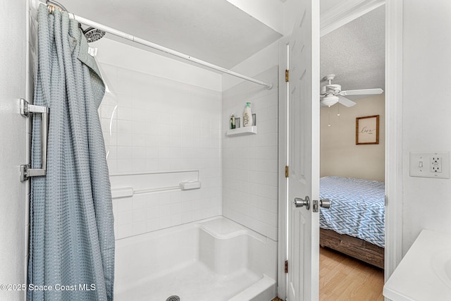 bathroom featuring ceiling fan, curtained shower, and hardwood / wood-style floors