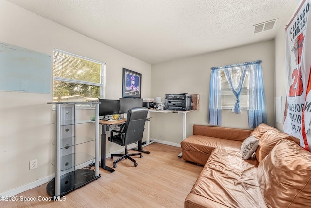 office with a textured ceiling and light hardwood / wood-style flooring