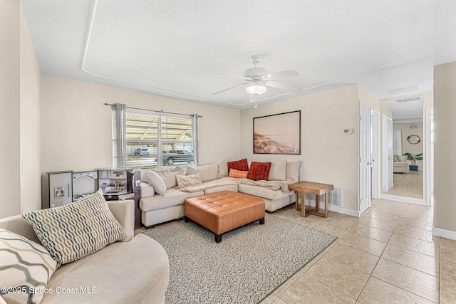 living room featuring light tile patterned flooring, a textured ceiling, and ceiling fan