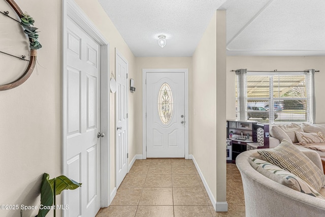 foyer with light tile patterned floors and a textured ceiling