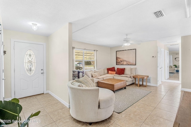 tiled entrance foyer with ceiling fan and a textured ceiling