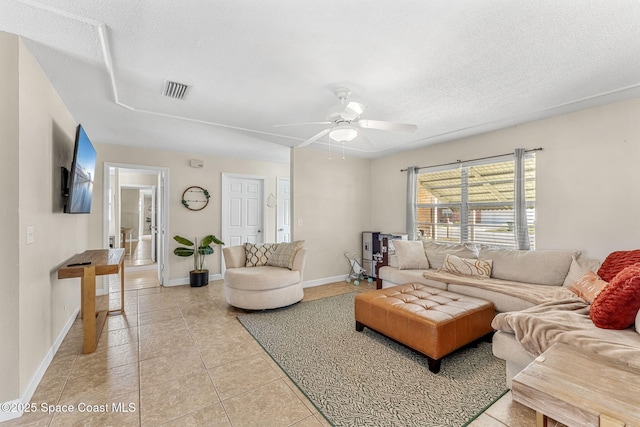 tiled living room featuring ceiling fan and a textured ceiling