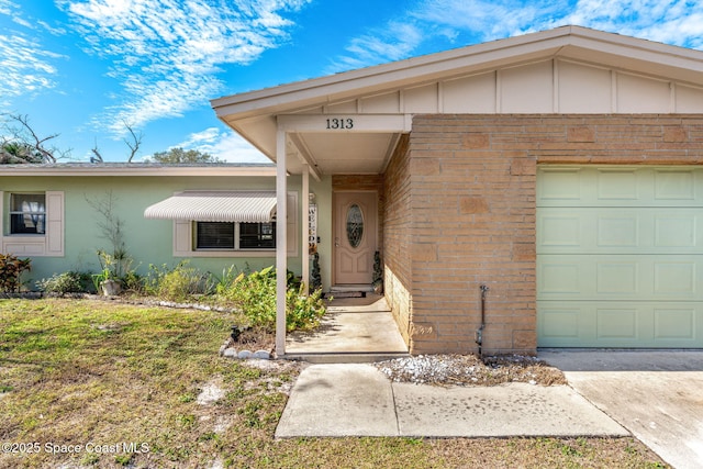 doorway to property featuring a garage and a yard