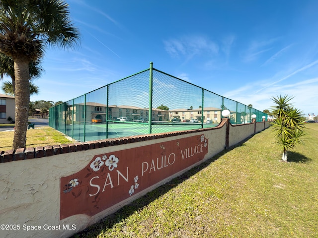 view of tennis court featuring a lawn