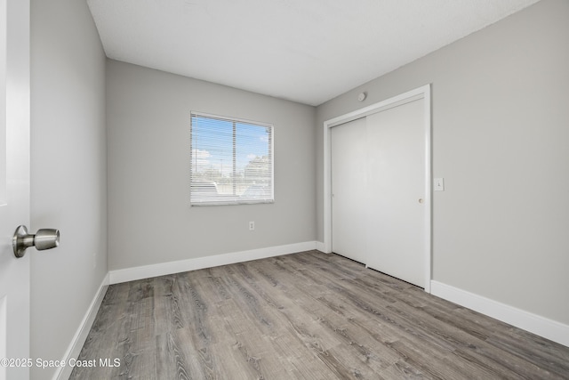 unfurnished bedroom featuring light hardwood / wood-style flooring and a closet