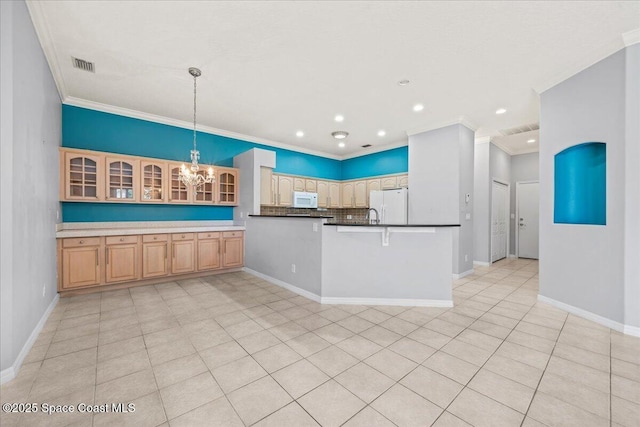 kitchen with a chandelier, hanging light fixtures, kitchen peninsula, white appliances, and backsplash