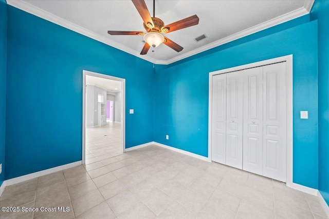 unfurnished bedroom with light tile patterned floors, ornamental molding, a closet, and ceiling fan