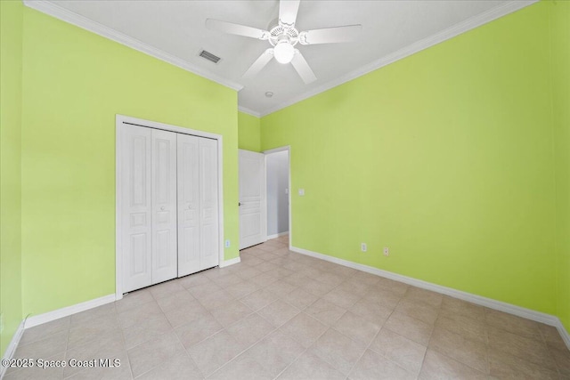 unfurnished bedroom featuring ornamental molding, light tile patterned flooring, ceiling fan, and a closet