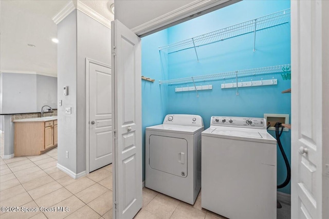 laundry area with ornamental molding, separate washer and dryer, sink, and light tile patterned floors